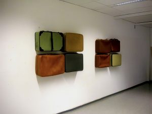 Installation mit Koffern die an der Wand hängen.